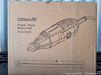 Cardboard box with illustration of Goxawee rotary tool model G4007 printed. Front side with brand, model, and warning text about reading instruction manual.