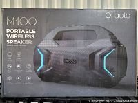 Front of box showing Oraolo M100 speaker image and key features like Bluetooth 5.0, hands-free calling, TF card playback, stereo connection, TWS pairing, and LED lights.