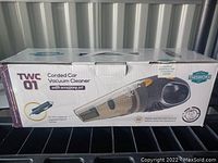 Photo of the boxed handheld corded car vacuum cleaner showing the product image and key features on the box.