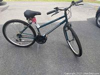 Full side view of the blue Diamondback Outlook six-gear mountain bike with knobby tires and black saddle.