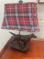 Side view of the lamp showing the dog base and plaid fabric shade with rounded rectangular shape.