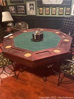 Front angle view of poker table showing playing surface, cup holders, chip/card compartments and poker chips in chip holder.