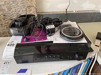 Front view of Yamaha RX-V685 receiver with small electronic accessories and cables on top, showing device front panel including buttons, display, and volume knob.