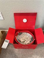 Red branded box opened, showing helmet and accessories inside