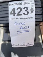 MaxSold sticker label on equipment indicating lot number and PowerBlock brand