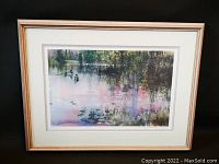 Full view of the framed print showing the artwork under glass with a white mat and gold frame.