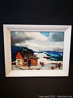 Full view of the framed folk art painting showing a rustic cabin in a snowy mountainous landscape with two figures in the foreground.