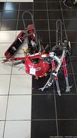 Top view of multiple kids electric scooter frames with red plastic fronts and exposed wiring.