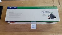 Box of Gaiam Pilates Mat showing front with product name and brand.