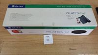Box of Gaiam Pilates Mat with branding and product information visible on top.
