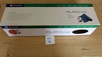 Closed box with Gaiam Pilates mat branding and product info
