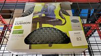 Photo front view of Gaiam Restore Balance Cushion in original packaging showing textured, gray inflatable cushion and product branding.