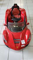 Front view of the red LaFerrari kids electric ride on car showing the seat, steering wheel, and Ferrari logos.