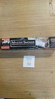 Photo showing the full Master Smoker box featuring the product name and image of the smoker device in its packaging.