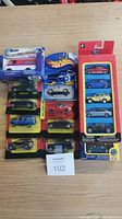 Photo of multiple toy cars in original blister packaging and a boxed delivery van toy