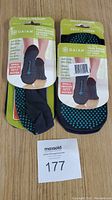 Front view of both yoga socks with packaging showing size and grip details.
