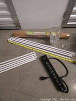 Lot showing cork roll, crystal vases, white tension rods, and black surge protector with USB ports.