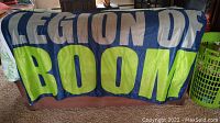 Flag laid out on floor with text 'LEGION OF BOOM' in blue, white, and green colors.