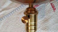 Close-up photo of the brass electric socket unit with a knob on the lamp's base