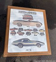 Full view of framed Corvette mirror showing colors, graphics of old Corvette cars from 1953-1973, wood frame and reflective surface.