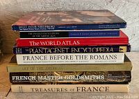 Stack of eight vintage hardback books with visible titles related to history, geography, and French culture.