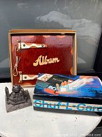 Vintage wooden photo album, card shuffle deck box, and metal architectural decor together