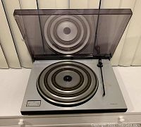 Front view of Beogram 1602 turntable with lid open showing platter and tonearm