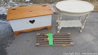 Overall view showing kids toy box with heart cutout, white side table and rolled-up wooden slatted piece.
