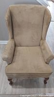 Front view of beige wingback chair showing seat, armrests, and backrest