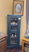 Full view of antique curio cabinet showing two glass doors and contents inside including ceramic and glass items.