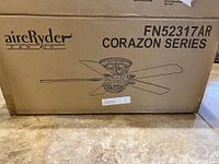 Box of aireRyder Corazon Series ceiling fan showing model FN52317AR and illustration of fan design.