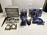 Overview of all items included in the lot: power tools, storage cabinet, hardware packs, security alerts.