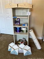Wood crafts shelf with trays, ribbons and poster board beside it