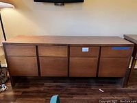 Front view of the solid wood office credenza showing eight drawers in total, with wood fronts and clean design.