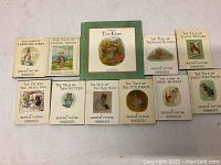 Photo showing full set of 11 Beatrix Potter children's books arranged in two rows.