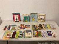 Wide view of many children's books from vintage to contemporary laid out on a table.