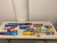 Overview of assorted kitchen wraps, aluminum foil, freezer bags, plastic wrap, and wax paper boxes arranged on a table.