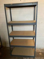 Front view of metal garage shelving unit, showing all five particleboard shelves and gray metal frame.