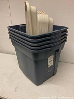 Stacked five blue Roughneck bins with beige lids displayed inside the top bin.