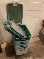 Stacked large plastic storage totes with matched lids showing colors and overall condition