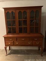 Front view of Stickley 2-piece buffet and china hutch showing drawers and glass doors.