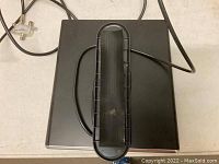 Top view showing black rectangular plastic base and attached cable