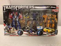 Front view of unopened box featuring Optimus Prime, Shockwave, Bumblebee figures in Transformers Dark of the Moon Streetside Bot Brawl set.
