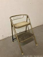 Side view of beige vintage metal folding step stool showing two steps and backrest