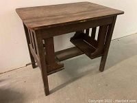 Front angled view showing the rectangular tabletop and side slat panels with shelf underneath