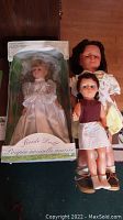 Three dolls shown together. Bride doll in box on left, two other dolls on right.
