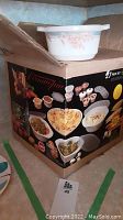 Box showing Corningware brand and images of different ovenware shapes included in the 27 piece set
