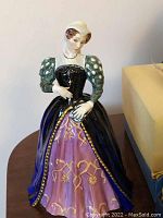Front view of the hand-painted bone china figure showing coloration and detail on gown and sleeves.