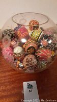 Front view of clear etched glass fishbowl filled with hand-painted eggs