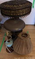 Full view of both vintage lamps showing the wicker lamp with a decorative wicker shade and the metal lamp with a wide metal shade